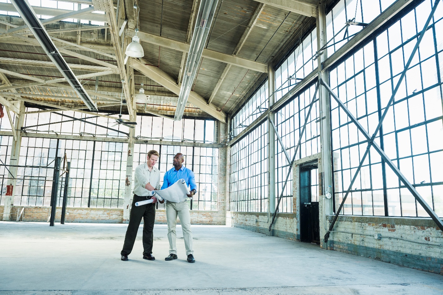 People reading blueprints in warehouse