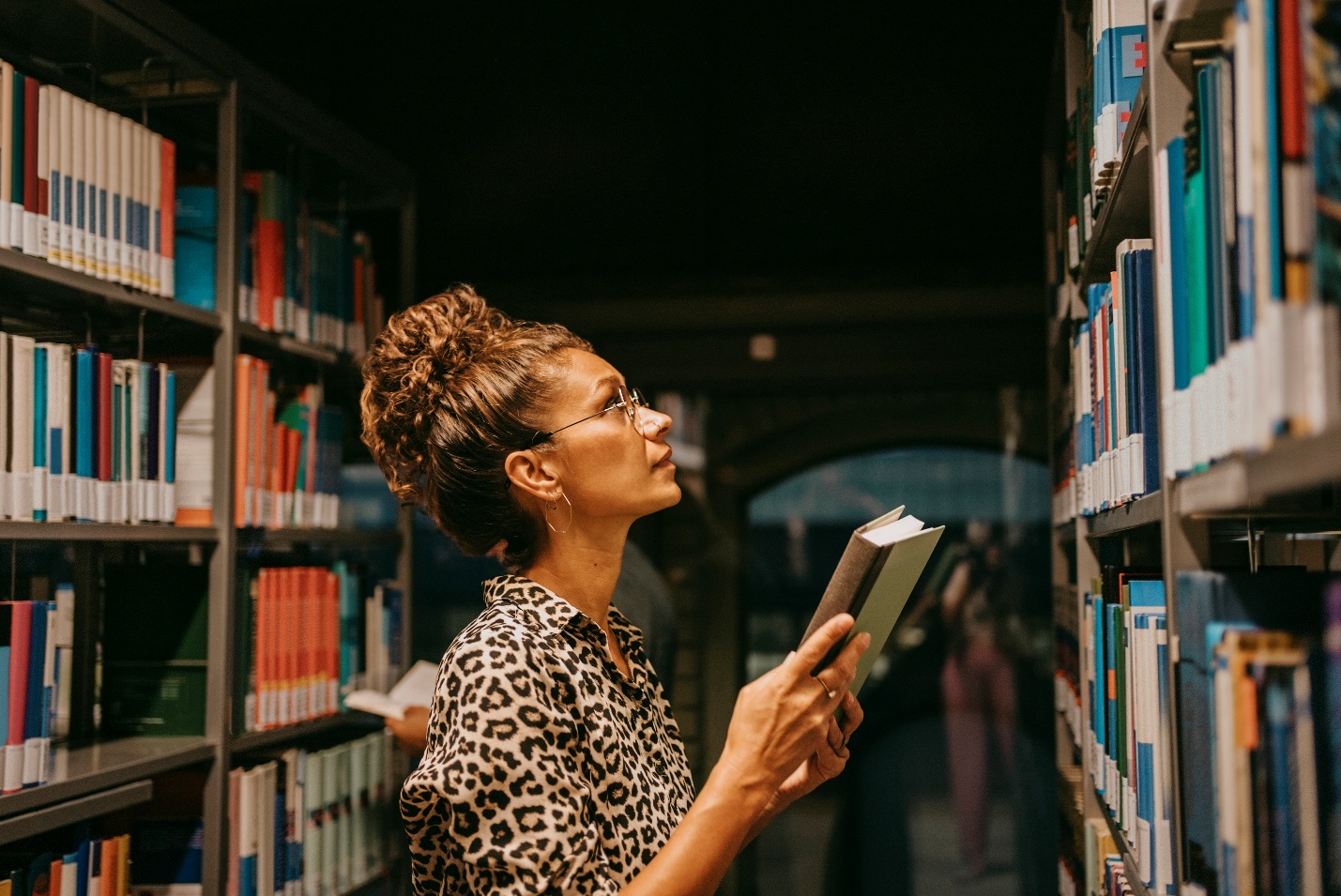Woman holding book in library